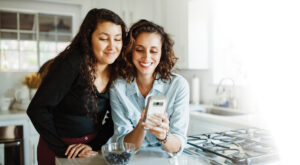 Mother and daughter are making an online appointment using their cellphone