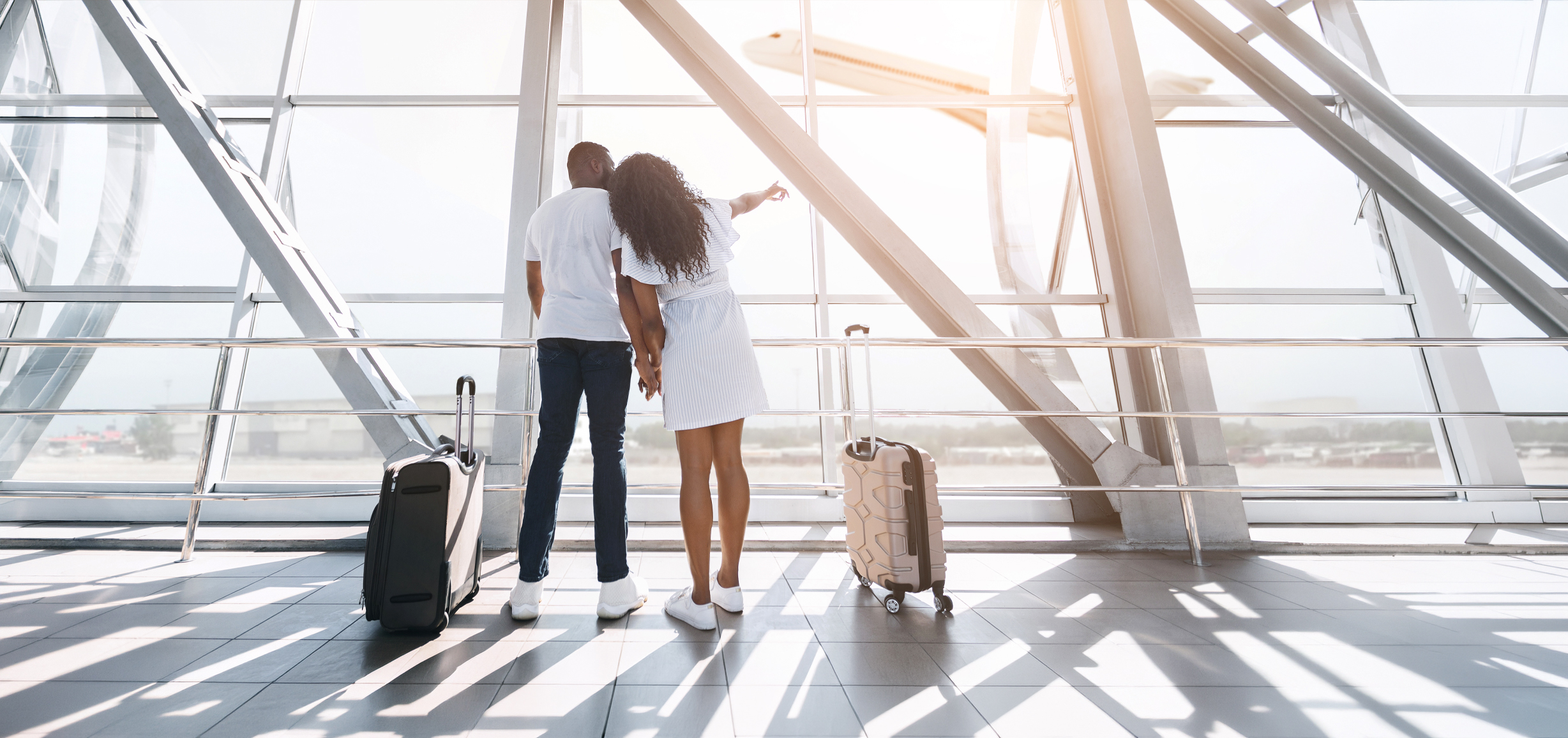 Black couple at the airport looking out towards the horizon